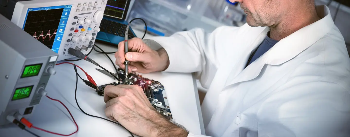 Un tecnico al banco del laboratorio, con l'oscilloscopio